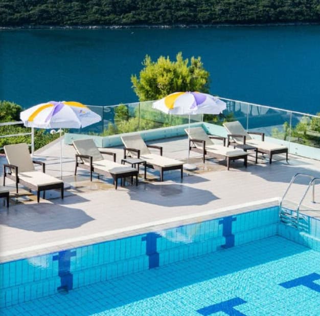 Bazen sa ležaljkama i suncobranima pored, smešten na terasi sa pogledom na jezero